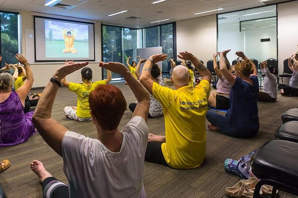 Lokalni stanovnici isprobavaju Falun Gong meditaciju.