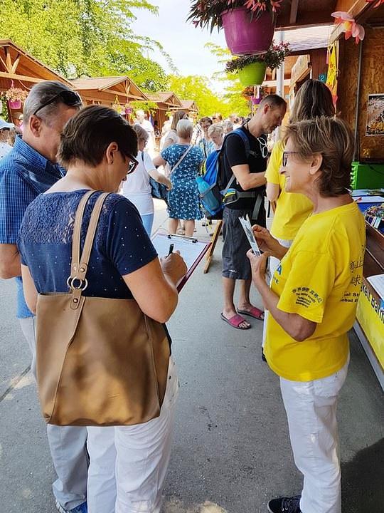 Jedan bračni par potpisuje peticiju kojom se poziva na okončanje progona Falun Gonga