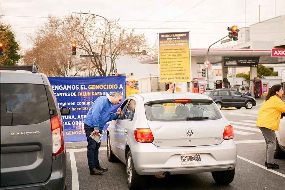 Praktikanti vozačima daju informacije o Falun Gongu.
 