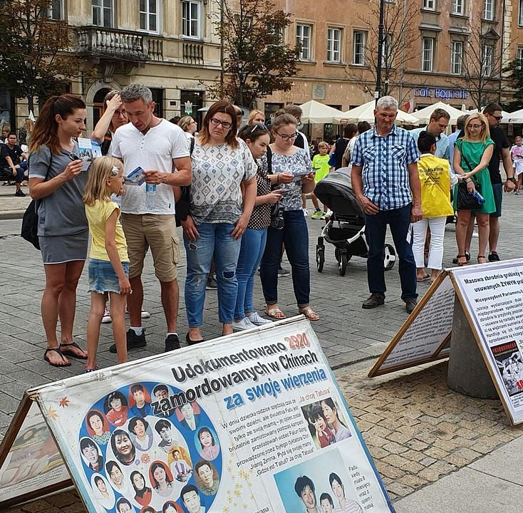 Prisutni na festivala čitaju informacije o Falun Gongu i progonu.