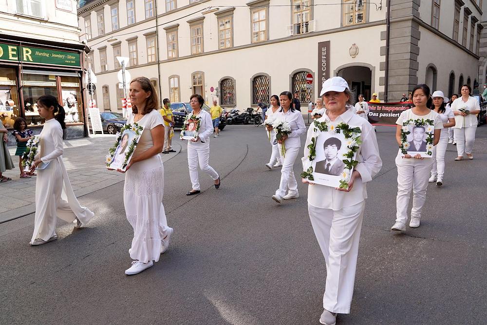 Praktikanti drže fotografije praktikanata koji su umrli od posljedica progona, kako bi se razotkrila prava priroda KPK.