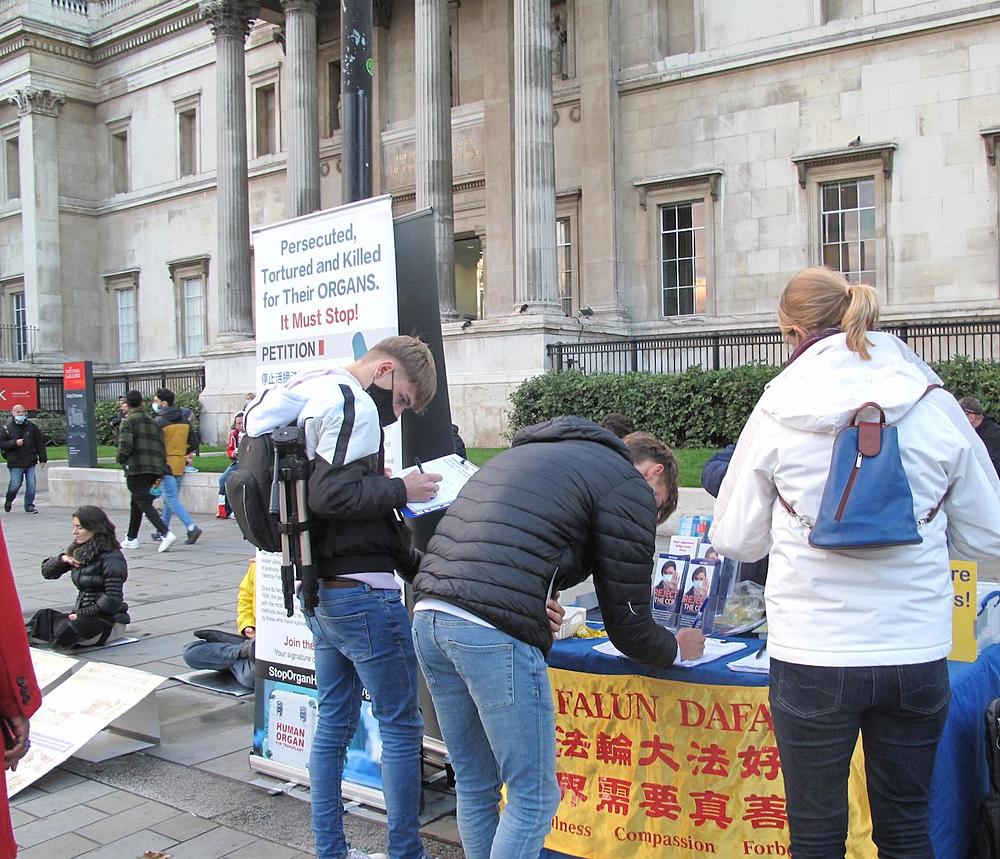 Prolaznici potpisuju peticiju kojom pozivaju na okončanje brutalnosti prema Falun Gong praktikantima u Kini