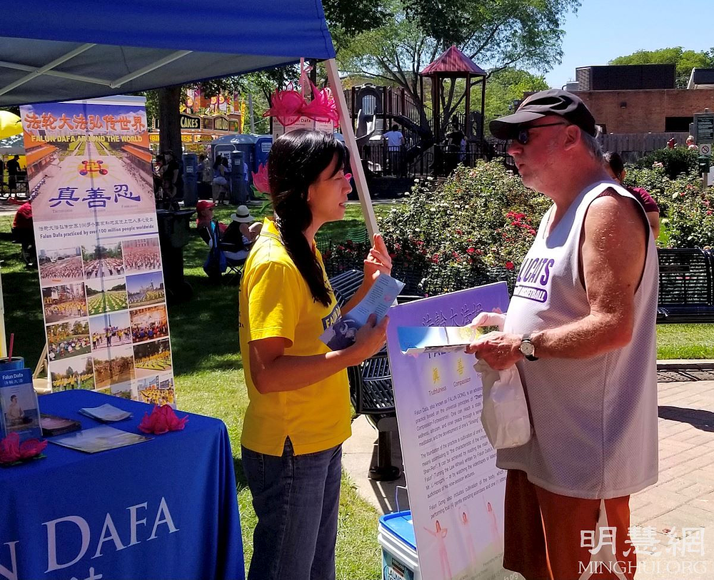 Posjetitelji na Falun Dafa štandu tokom festivala