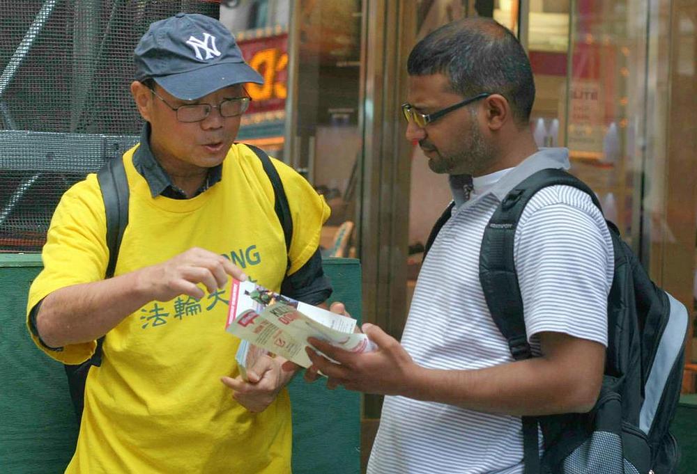 Praktikant Falun Dafa jednom prolazniku govori o progonu u Kini.