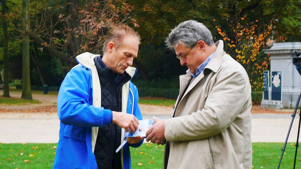  Prolaznik zastaje kako bi razgovarao s praktikantom i naučio više o Falun Dafa.