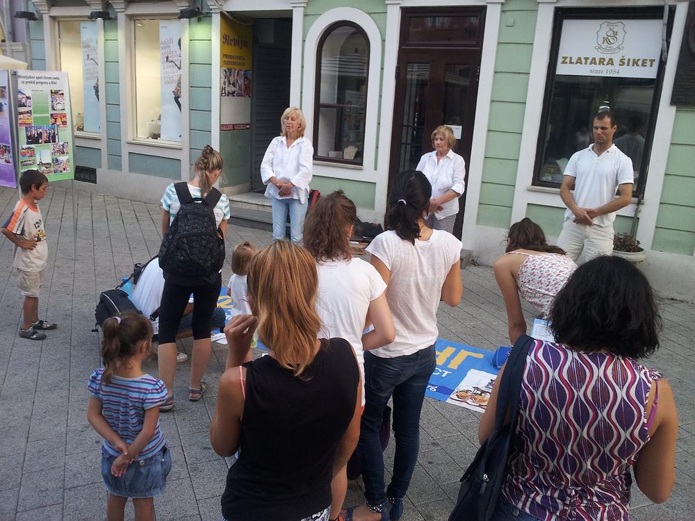 Prolaznici posmatraju prezentaciju Falun Gong vježbi u Novom Sadu