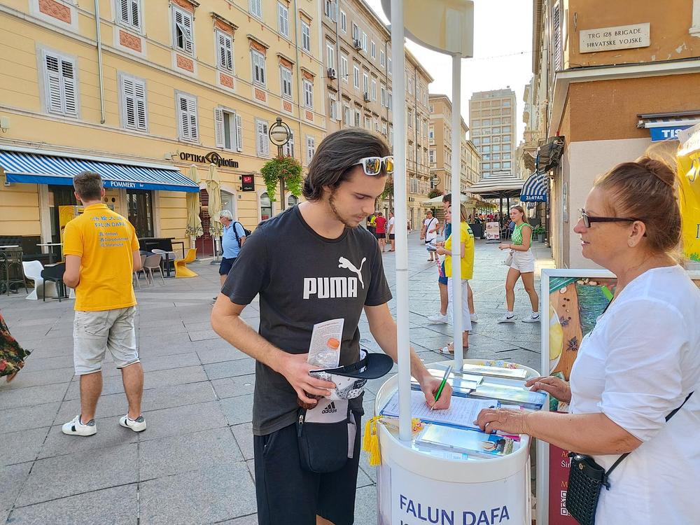 Prolaznici potpisuju peticiju za prestanak progona. 