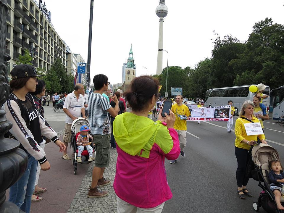 Gledaoci iz Kine gledaju protestni marš.