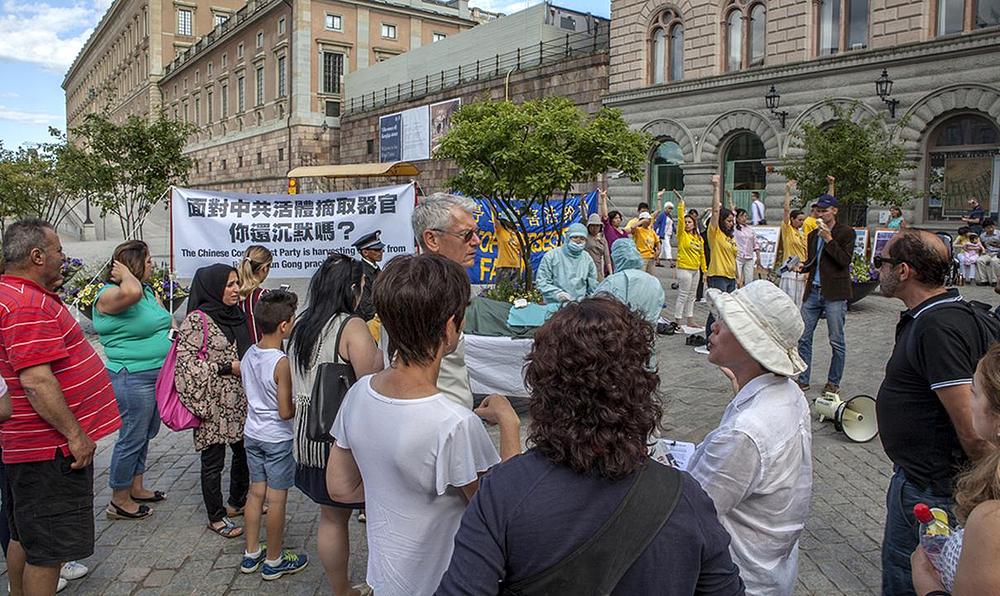 Inscenacija prisilne žetve organa na Mynttorget trgu. Na transparentu piše: „Hoćete li ostati nijemi kada ste suočeni sa prisilnom žetvom organa?“