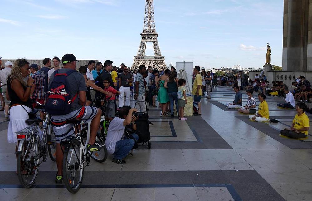 Turisti gledaju praktikante kako izvode vježbe. 