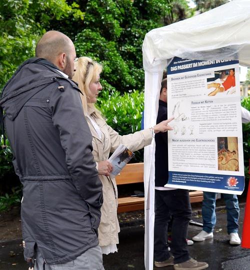 Žena svom prijatelju prevodi tekst sa postera