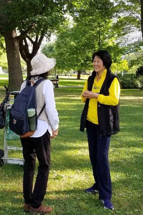 Falun Gong praktikantica razgovara sa turistkinjom iz Kine