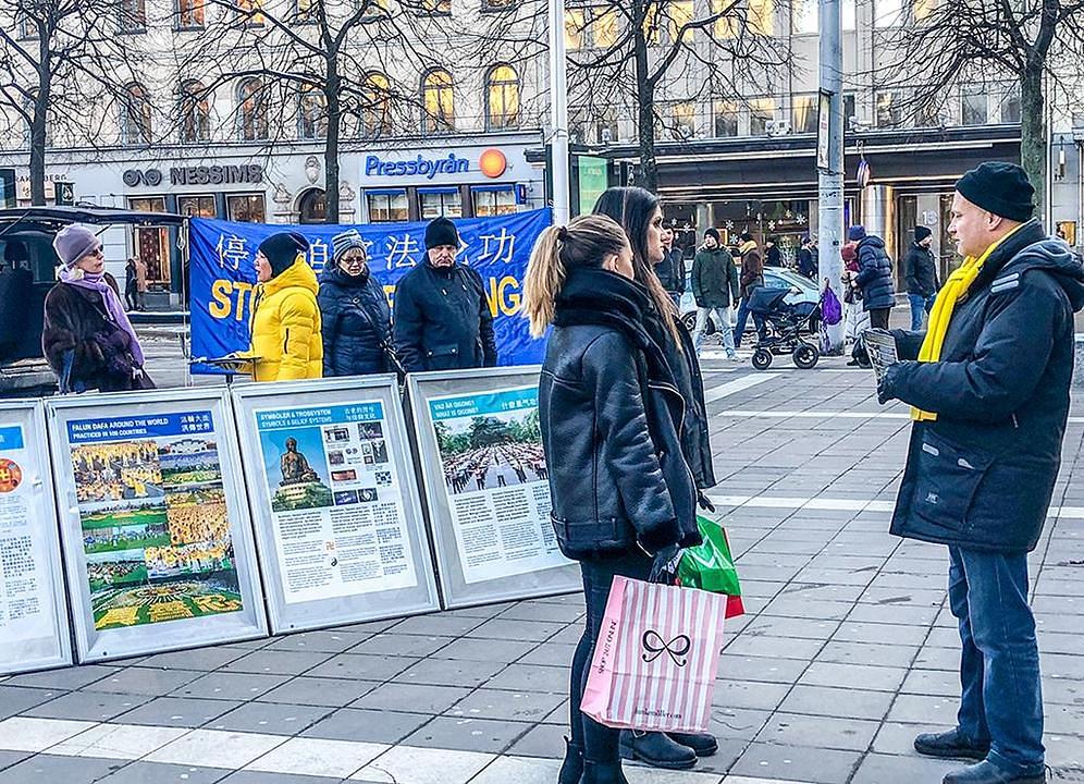 Prolaznici se informiraju o Falun Dafa na trgu Norrmalmstorg u Stokholmu 20. januara 2018.