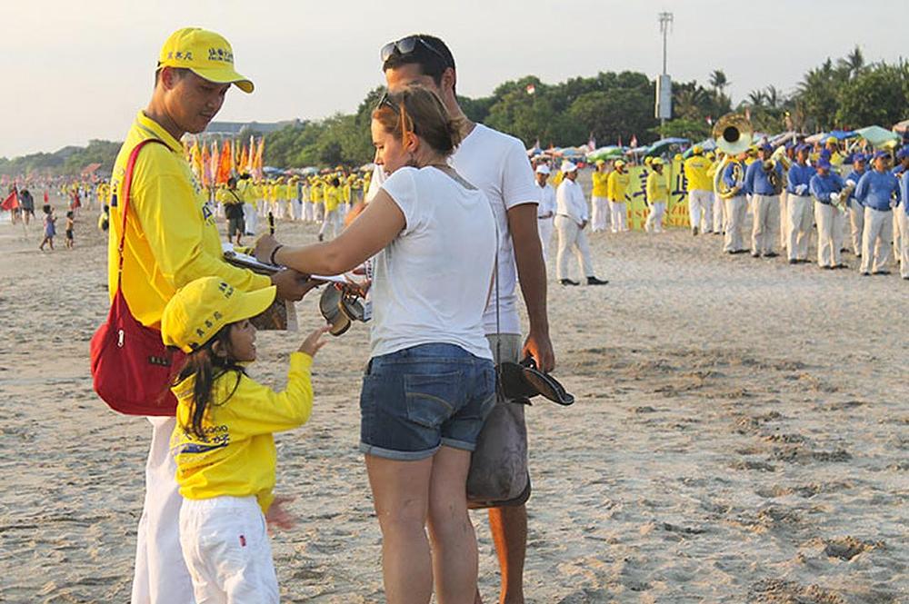 Turisti na plaži saznaju za progon i potpisuju peticiju kojom se osuđuje gaženje ljudskih prava u Kini.