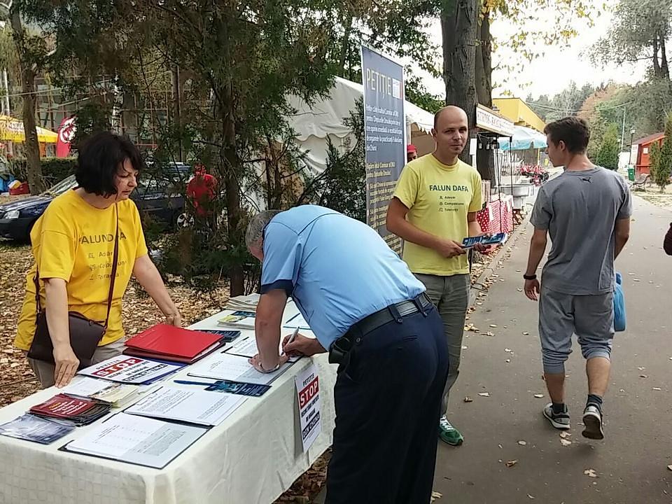 Policajac potpisuje peticiju kojom se podržavaju sudske tužbe protiv Jiang Zemina, bivšeg kineskog lidera koji je zabranio Falun Dafa 1999. godine. 