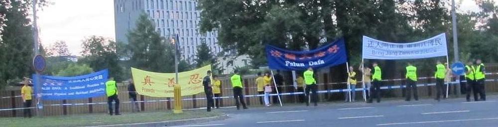 Praktikanti Falun Gonga drže transparente na izlazu iz Varšavskog vojnog aerodroma
 