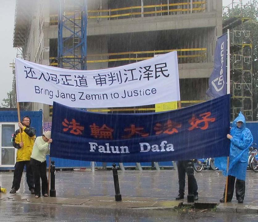 Ispred zgrade Parlamenta u Varšavi, povorka automobila sa Zhang Dejiangom polako prolazi pored transparenata 