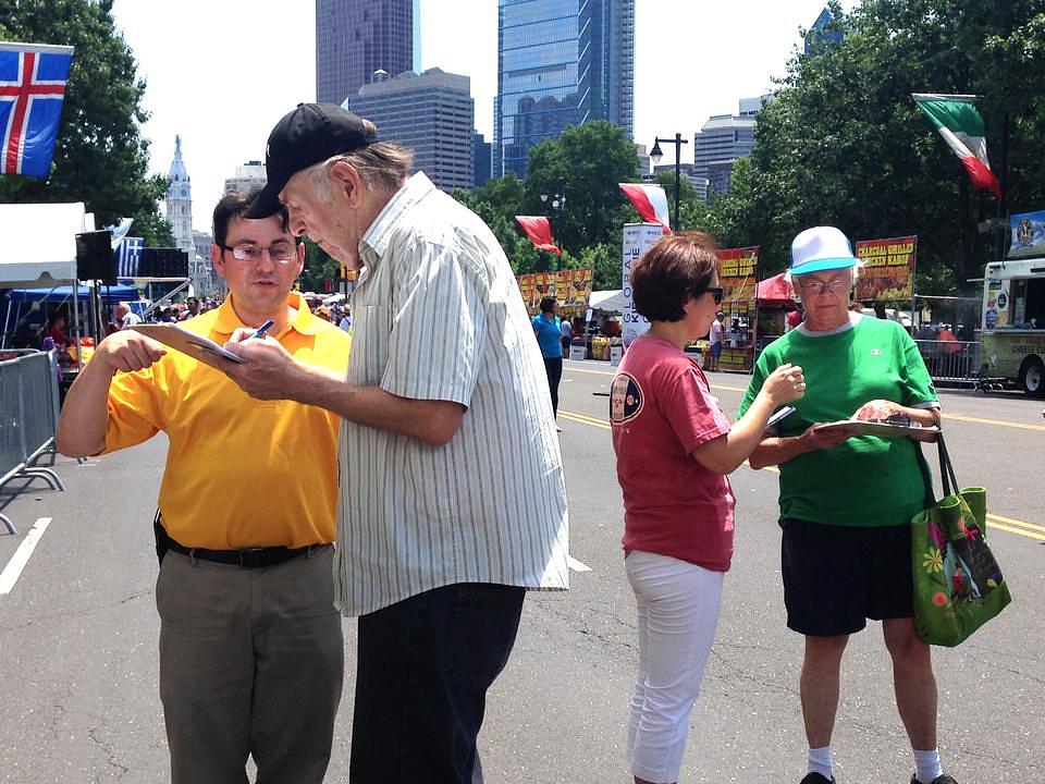Prolaznici potpisuju peticiju kojom osuđuju brutalni progon Falun Dafa u Kini