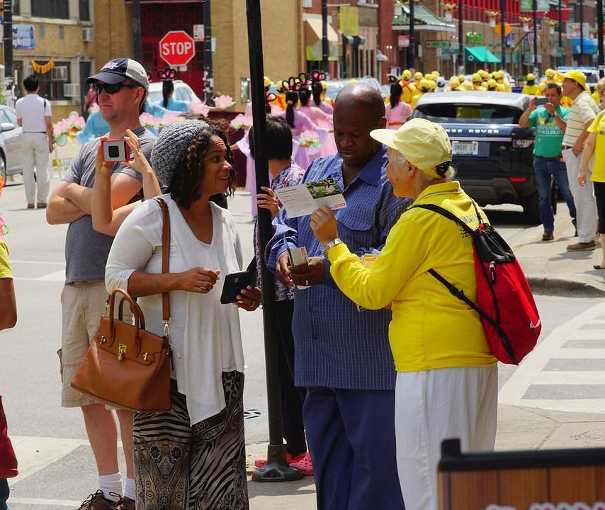 Praktikant objašnjava Falun Gong jednom paru.