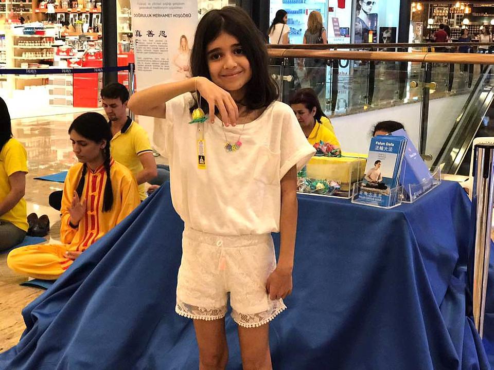 Melek pokazuje svoj origami papirni lotosov cvijet.