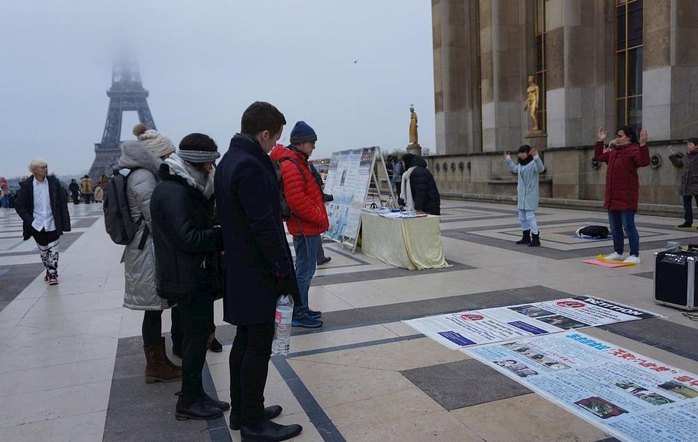 Turisti čitaju plakate na Trgu ljudskih prava.
 
