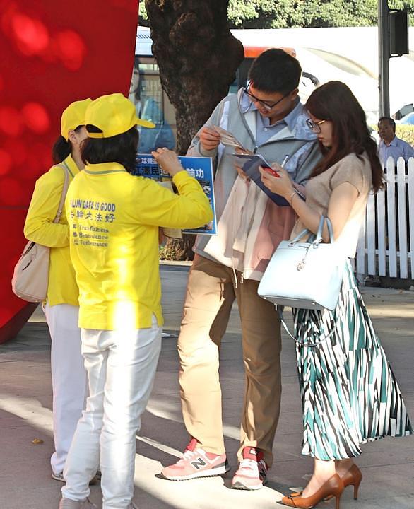 Prolaznici potpisuju peticiju da podrže tužbe protiv bivšeg kineskog vođe Jianga Zemina. 