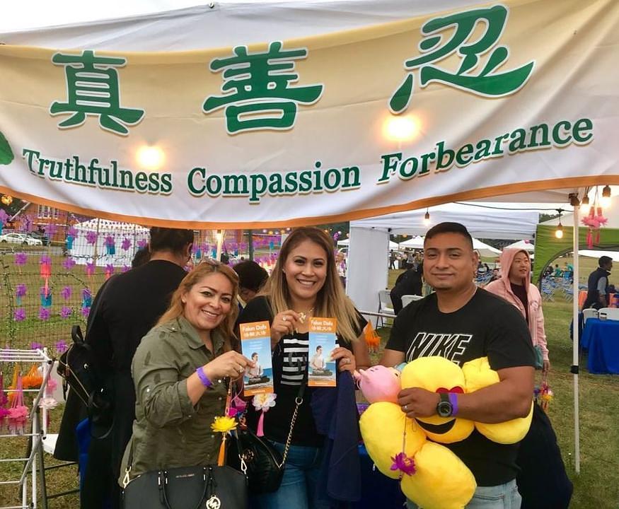 Gledaoci se zaustavljaju na Falun Dafa štandu radi dobivanja informacija o praksi.