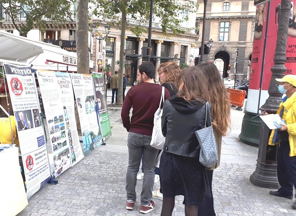 Prolaznici svraćaju da čitaju o Falun Gongu.