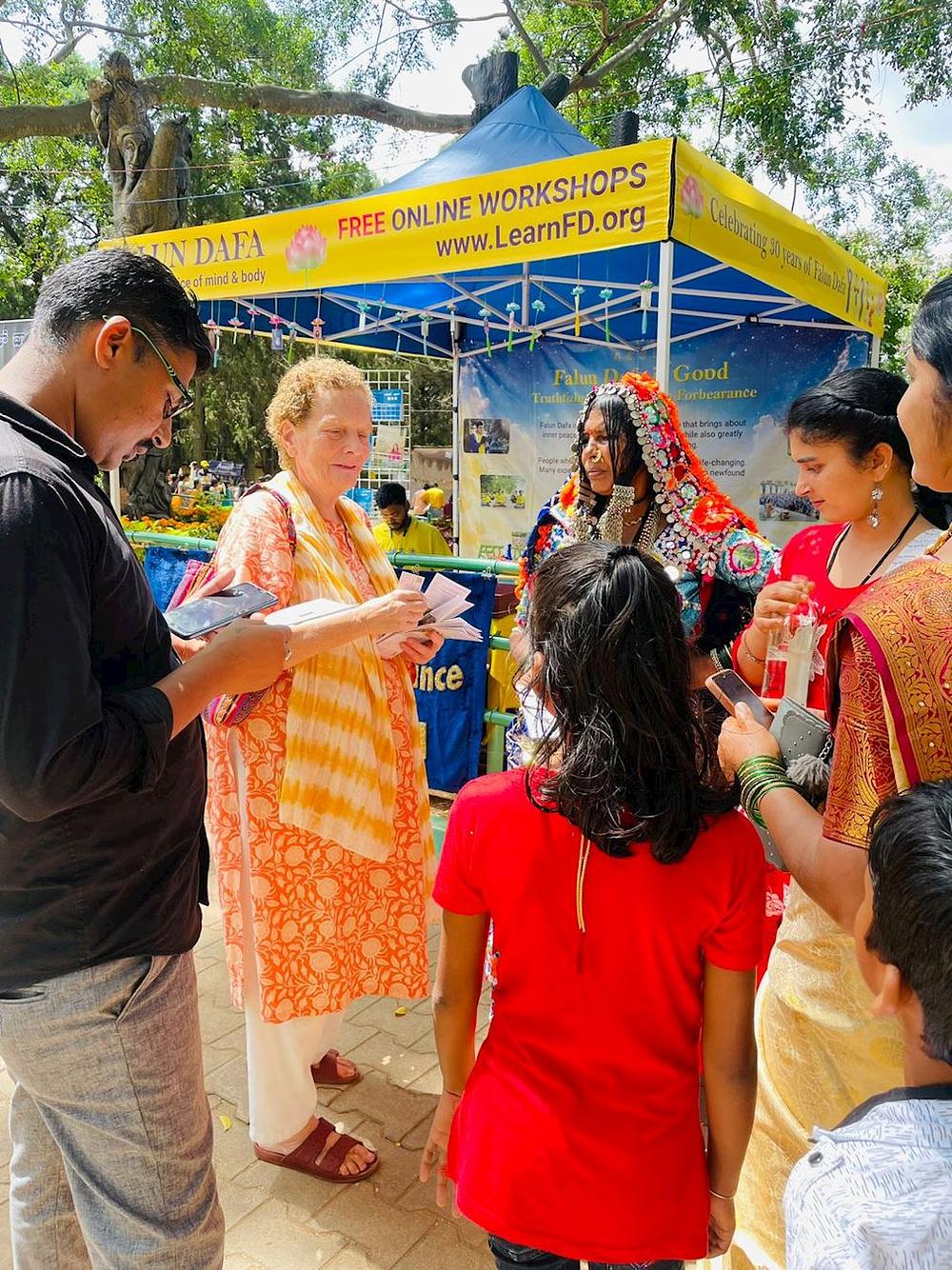  Praktikantica (druga slijeva) razgovara s ljudima o Falun Dafa. 
