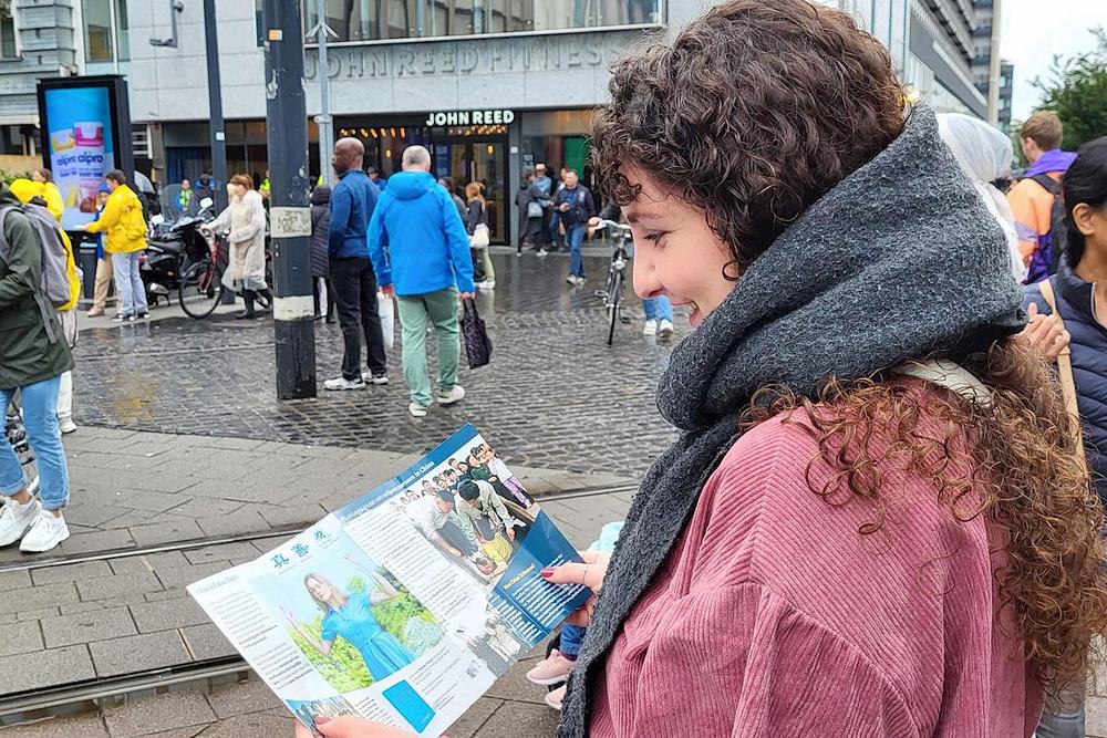 Mlada žena radosno čita letak.